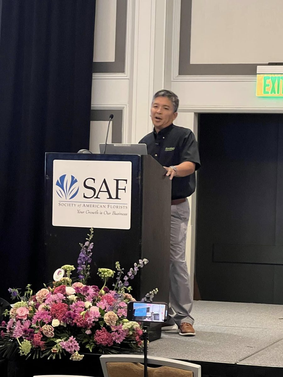 Renato Cruz Sogueco speaking at a Society of American Florists podium